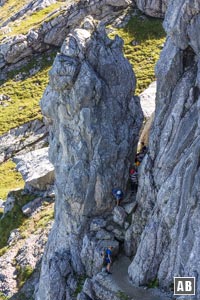 Der Weg zum Einstieg verjüngt sich und führt keck zwischen einer Felsnadel und den Nordabstürzen der Alpspitze hindurch