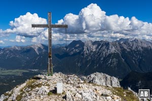 Gipfelkreuz der Oberen Wettersteinspitze mit dem Karwendelgebirge im Hintergrund