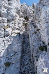Vor uns zieht eine schmale Rinne empor, oberhalb steht ein Steinmann. Zu diesem hochklettern - hinauf auf den Nordgrat der Vorderen Goinger Halt (I).