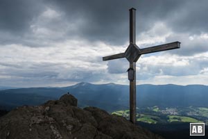 Das Gipfelkreuz des Großen Osser mit dem Großen Arber im Hintergrund