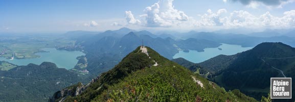 Aussicht vom Hauptgipfel auf den kreuzgeschmückten Vorgipfel - flankiert von Kochel- (links) und Walchensee (rechts)