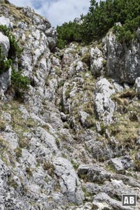 Im höchsten Punkt verengt sich die Furche zu einer steilen Kerbe - oben markiert mit einem roten Pfeil: Die Schlüsselstelle im Goldtropfsteig.