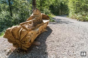 Der Schotterweg windet sich in Schleifen abwärts, vorbei an einigen Sitzmöglichkeiten