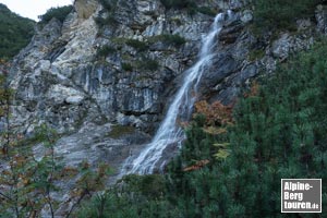 Beim steilen Aufstieg über die erste Felsstufe kommen wir an einem idyllischen Wasserfall vorbei