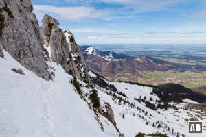 Schneeschuhtour Kampenwand: Nach dem Ende des Felsens und dem Drahtseil (links der Bildmitte) queren wir das abschüssige Gelände noch einige Schritte weiter hinaus. Hier der Rückblick auf das Felsende und die deutlichen Spuren im Schnee.