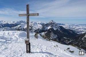 Das Gipfelkreuz des Ochsenälpeleskopf mit der steilen Felspyramide des Säuling im Hintergrund