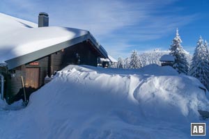 Die Schneemassen haben die Chamer Hütte fest im Griff. Im Hintergrund ist unser Ziel zu erkennen.