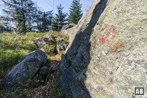 Mit ein wenig Spürsinn machen wir an einem der Felsen einen roten Wegepunkt aus